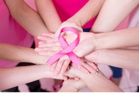 Pink Breast Cancer Awareness ribbon held by a group of hands